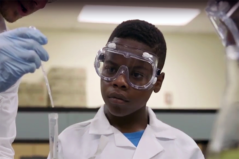 Middle School Student Watches as Instructor Prepares Solution in the Lab