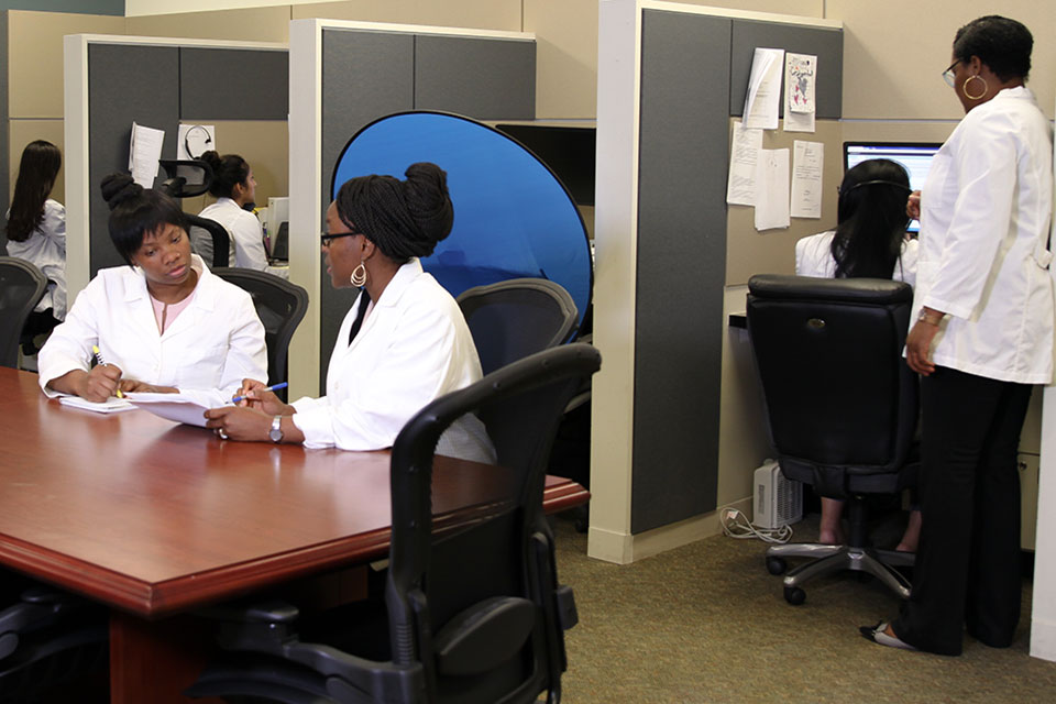 Pharmacists gather in the new Pharmacy e-Health Center to provide remote medication management assistance to patients.