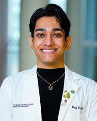 Portrait of Vraj Patel indoors wearing a UMSOP lab coat.