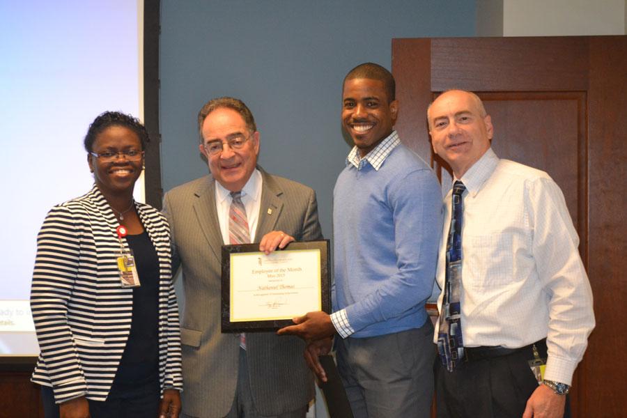 Nathaniel Thomas (in blue shirt) with from left, Toyin Tofade, PharmD, assistant dean for experiential learning, President Perman, and Mark Brueckl, RPh, assistant director of experiential learning.
