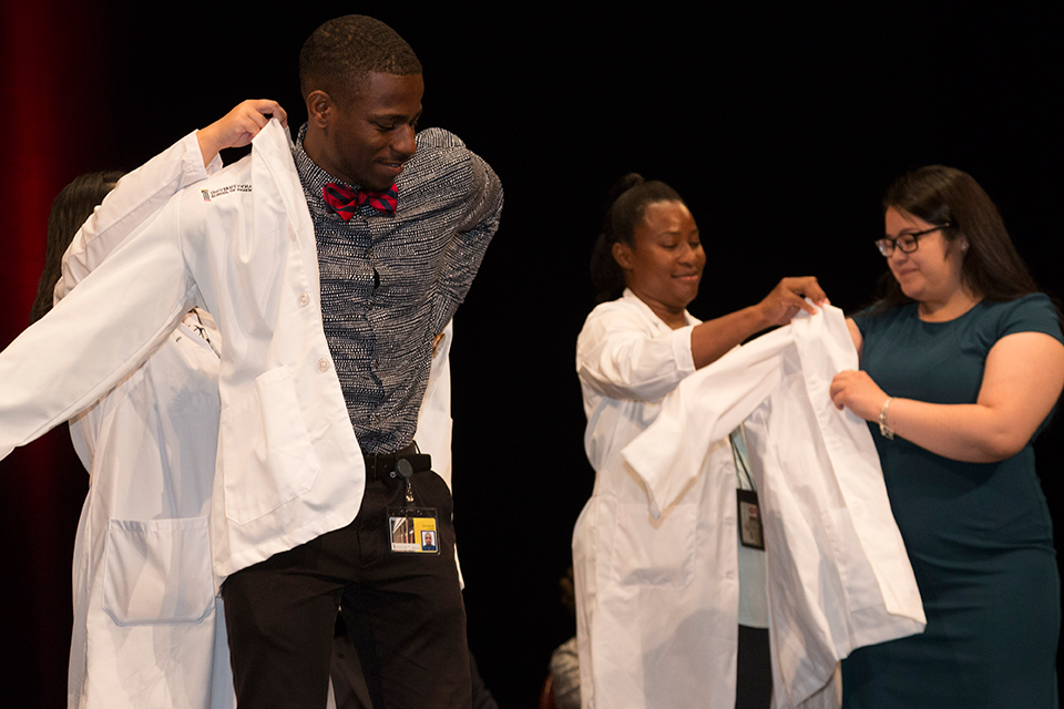 Students put on their white coats for the first time.