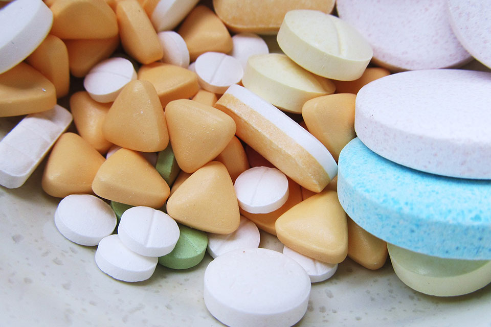 Multi-colored tablets in a pile on a table.