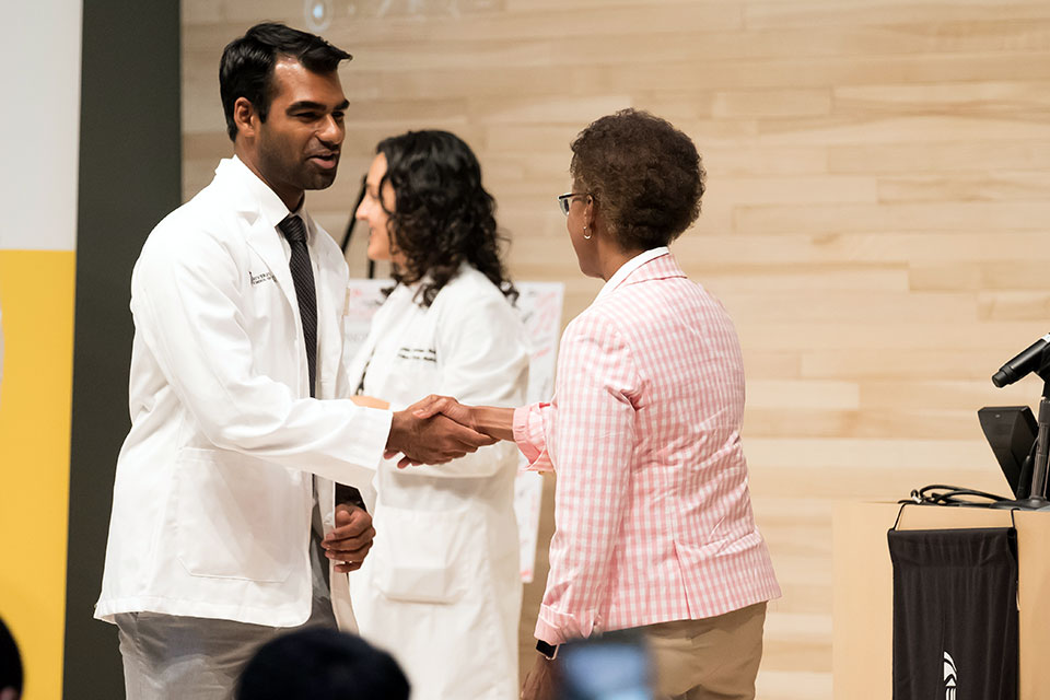 Student Shakes Hands with the Dean After Receiving White Coat