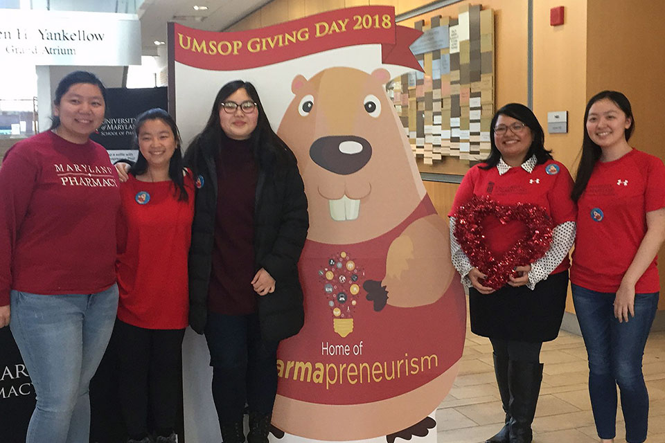 Dr. Cherokee Layson-Wolf and Student Pharmacists Pose with Pharmapreneur Phil, the School's Giving Day Mascot