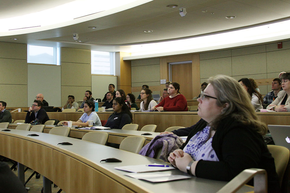 Audience members listen intently to presentations during the symposium.