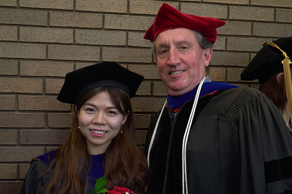 Dr. Alexander MacKerell poses for photo with his graduating student.