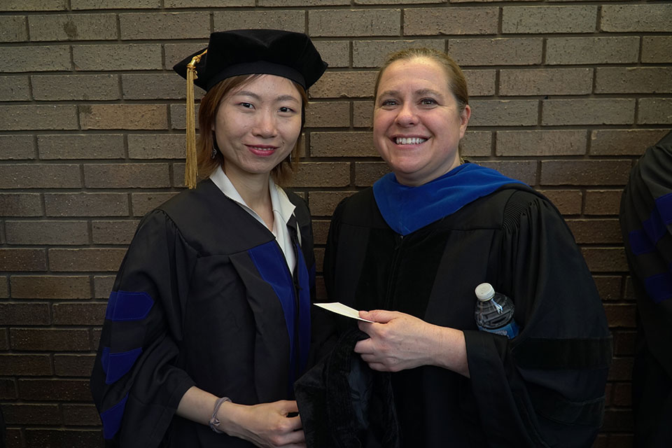 Dr. Maureen Kane poses for photo with her graduating student.