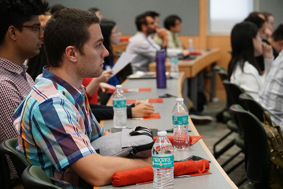 First-year students seated in lecture hall listening to Dean Natalie Eddington deliver opening remarks.