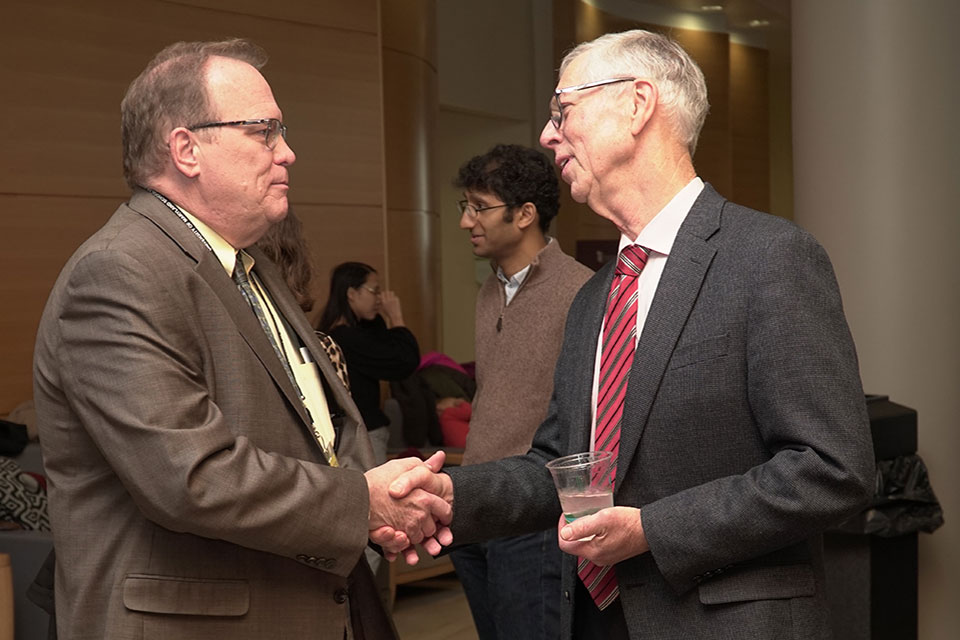 Dr. Beardsley shakes hands with William Cooper, senior associate dean for administration and finance at the School of Pharmacy.