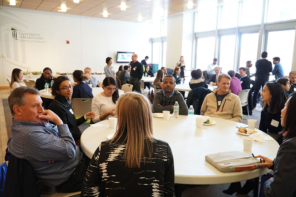 Faculty, students, and postdoctoral fellows converse over lunch before the symposium kicks off.