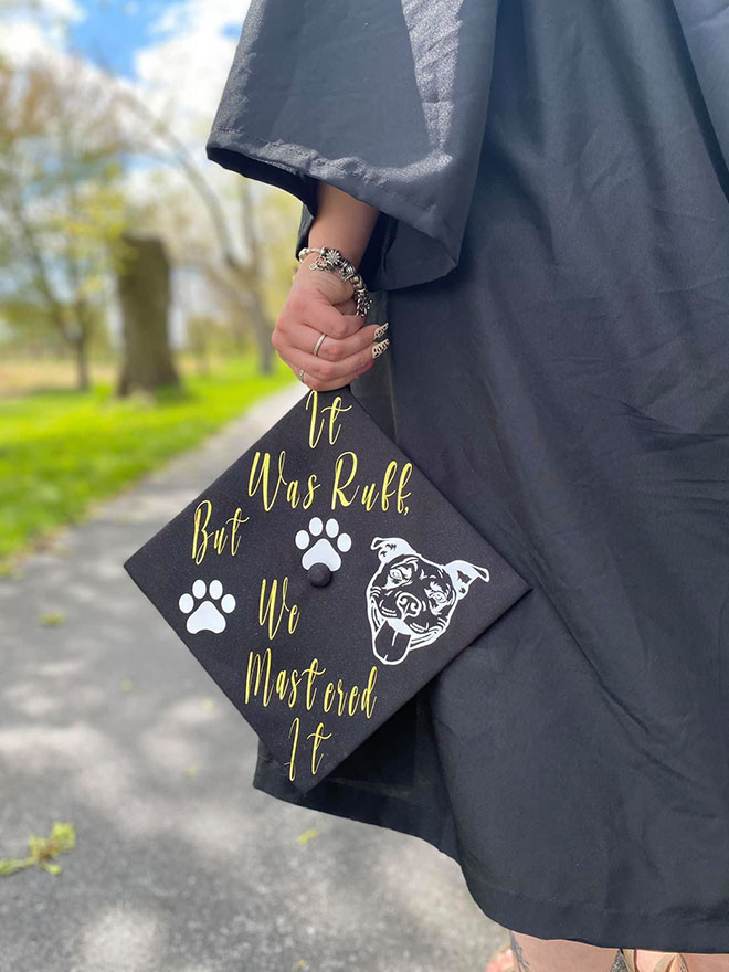 Graduate student hold graduation cap with message, 