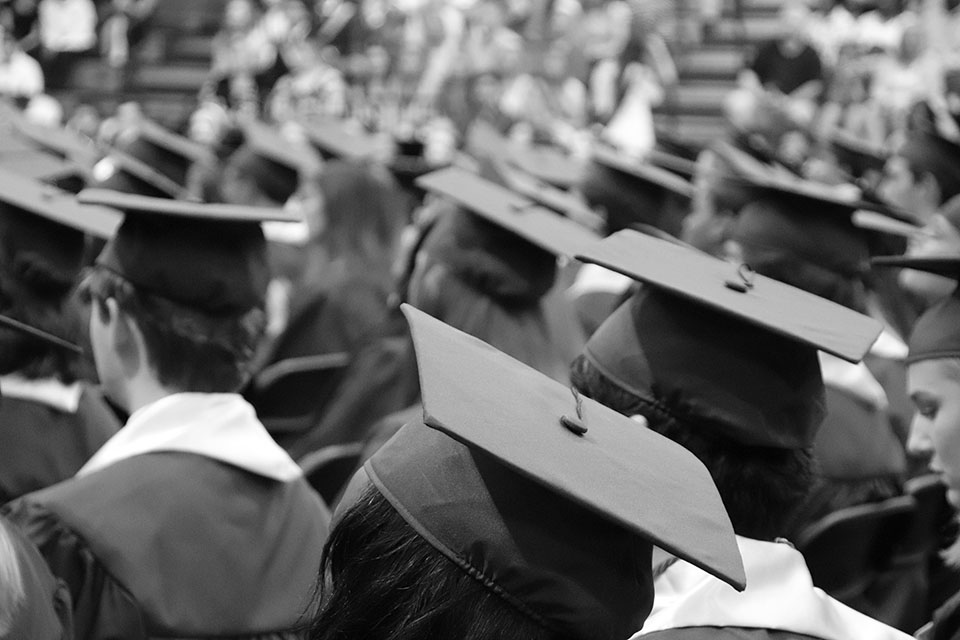 Black and white photograph of graduation caps.
