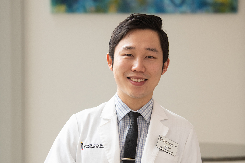 A headshot of Sean Kim in a white coat.