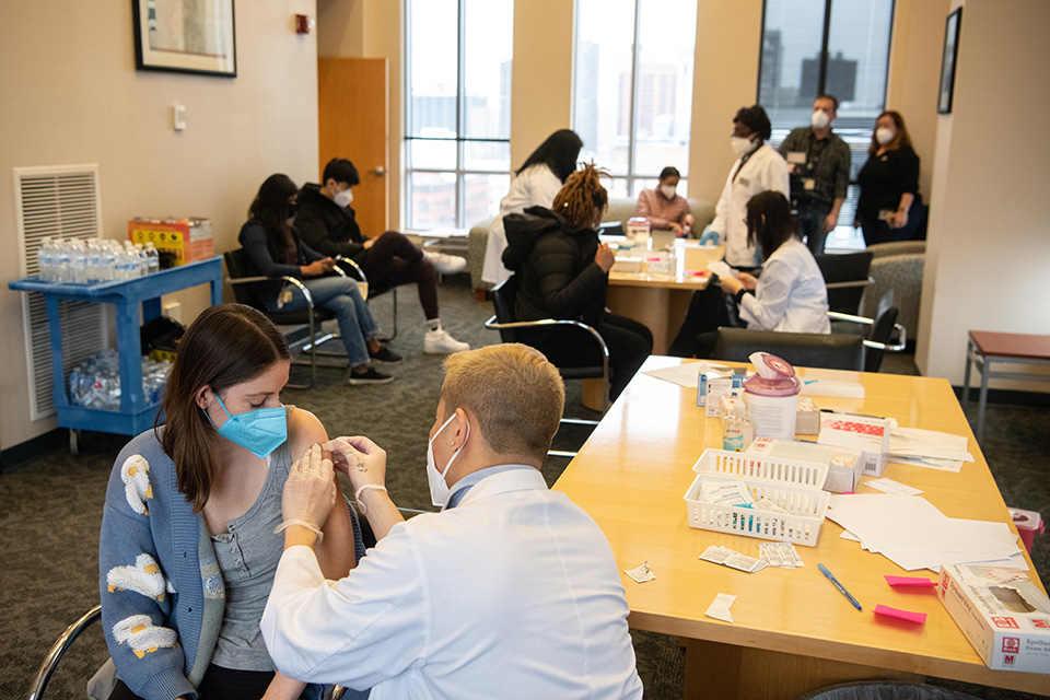 Kaitlyn Johnson receives her booster vaccine from Minh Ta at the School of Pharmacy Booster Clinic.