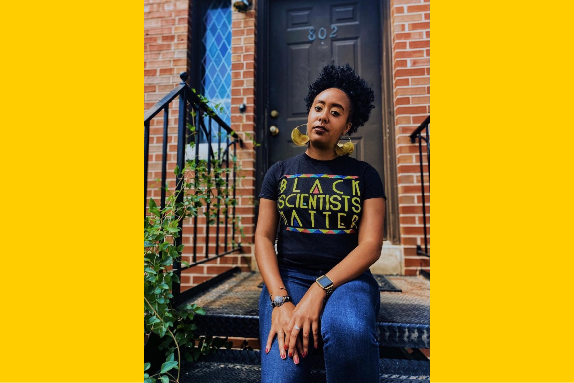 Dante Johnson sits on an outdoor stoop wearing a t-shirt that reads Black Scientists Matter.