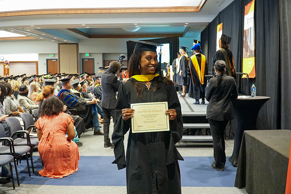 A student smiles with a certificate
