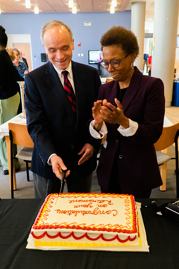 Frank Palumbo and Dean Natalie Eddington cut a cake celebrating his retirement.