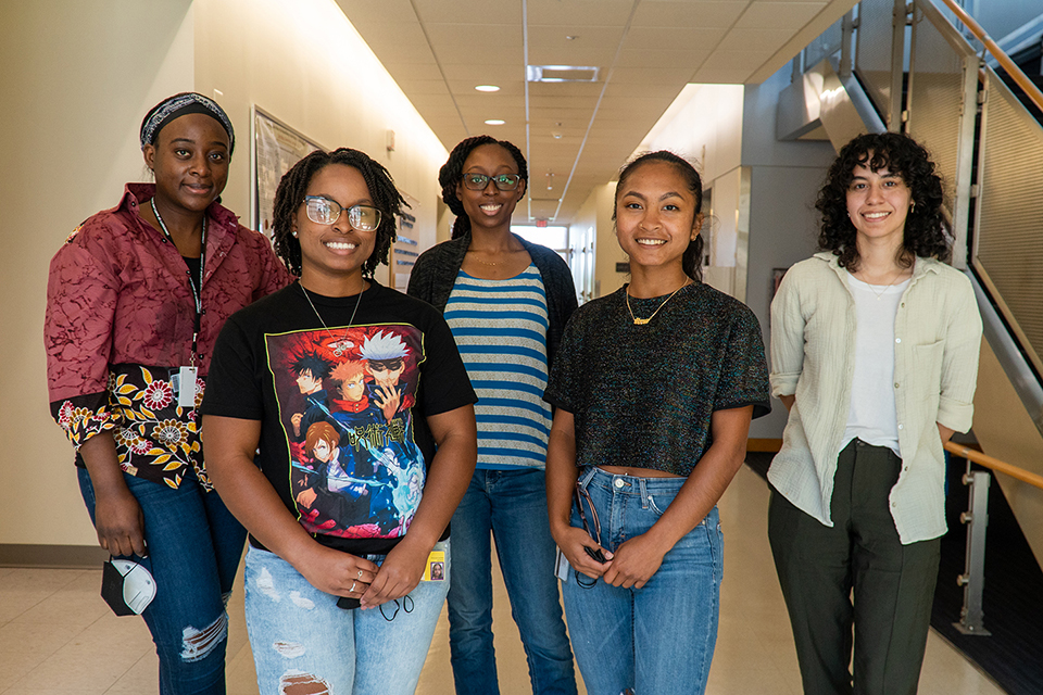 A group of students stand in a hallway.