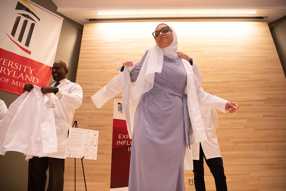 A student puts on the white coat.