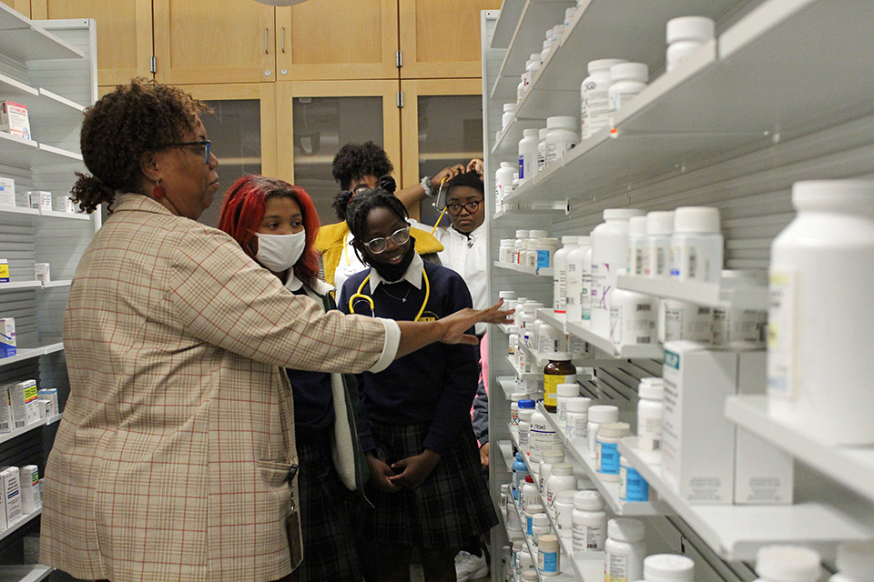 Girls in STEM students from Mother Mary Lange Catholic School look at a shelf of medications.