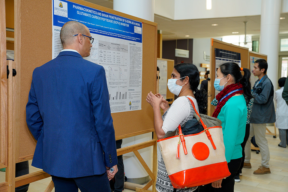 People interacting at the poster session at the UMB-JHU Drug Discovery Symposium