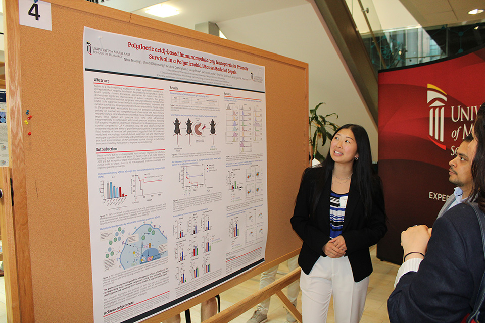 A student describes their poster at the FCBIS poster session.