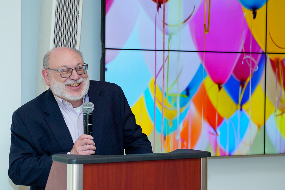 Raymond Love laughs while speaking at his retirement party.