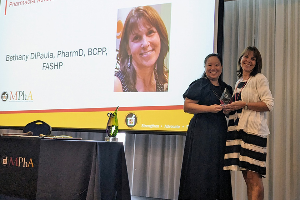 Bethany DiPaula receives an MPhA award from Deanna Tran.