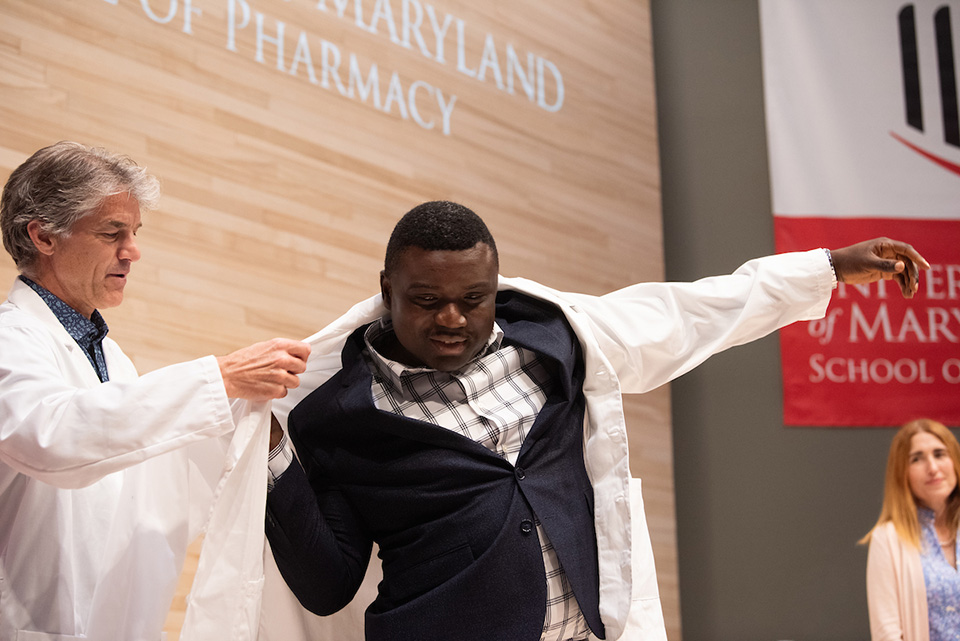 A student puts on a white coat.