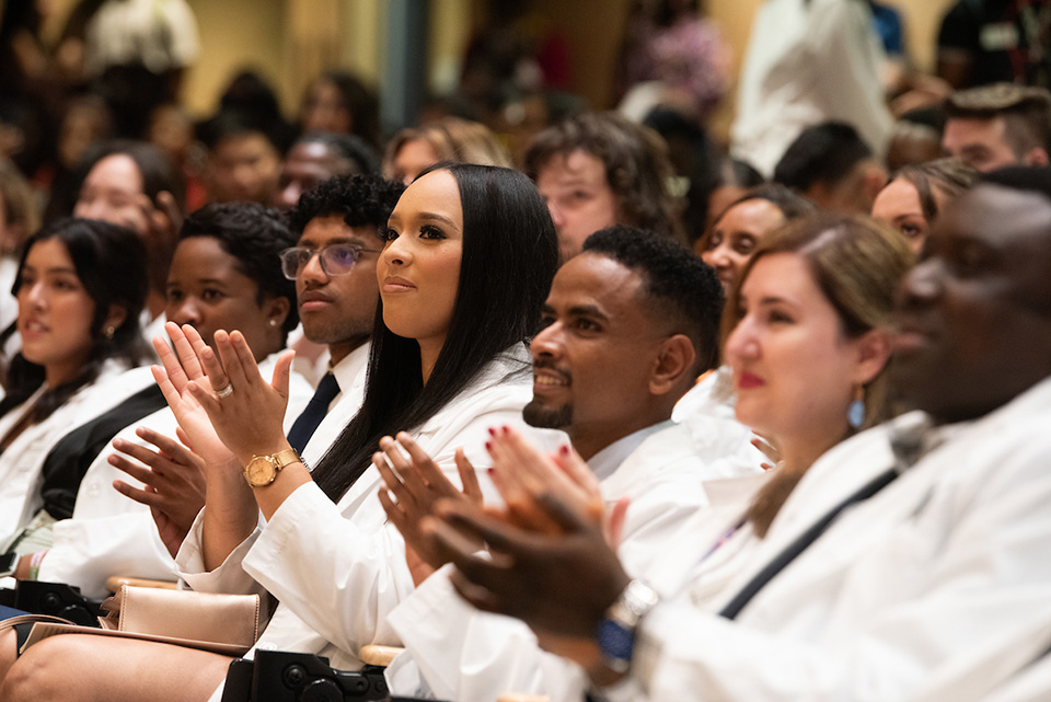Students clap at the White Coat Ceremony.