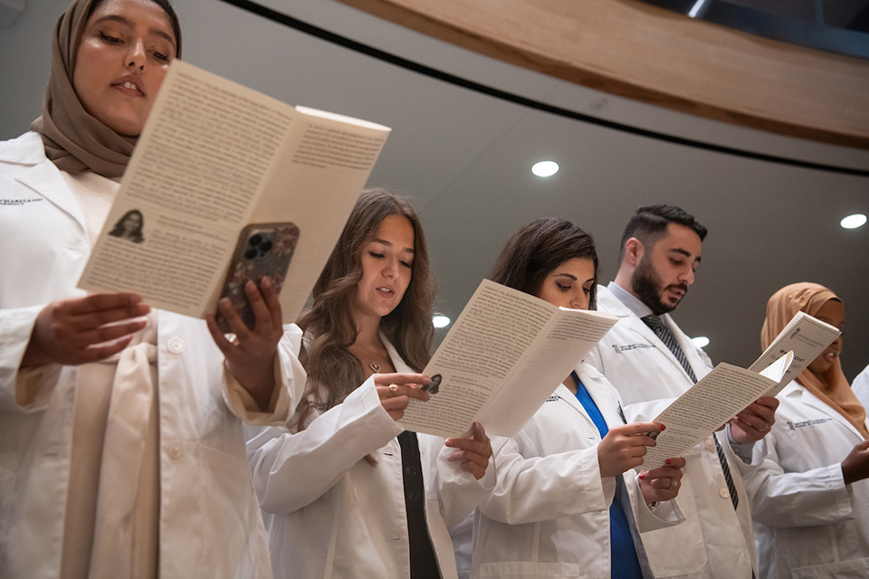 Student pharmacists reciting the oath of the pharmacist.