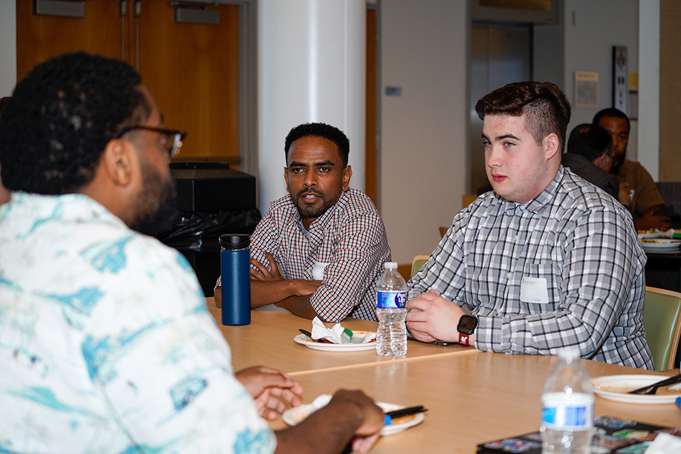 New students at PharmD orientation in conversation.