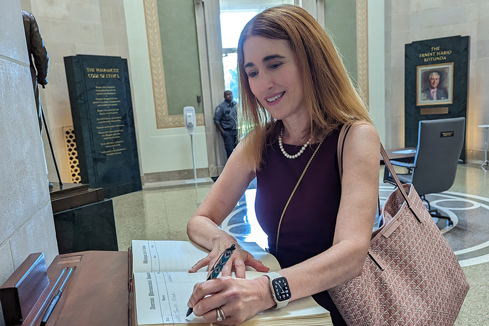 Dean Sarah Michel signing a book.