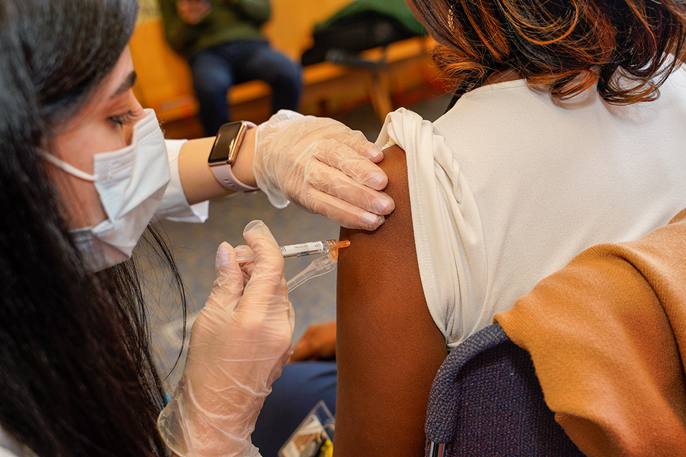 A student pharmacist gives an injection at the annual vaccination clinic.
