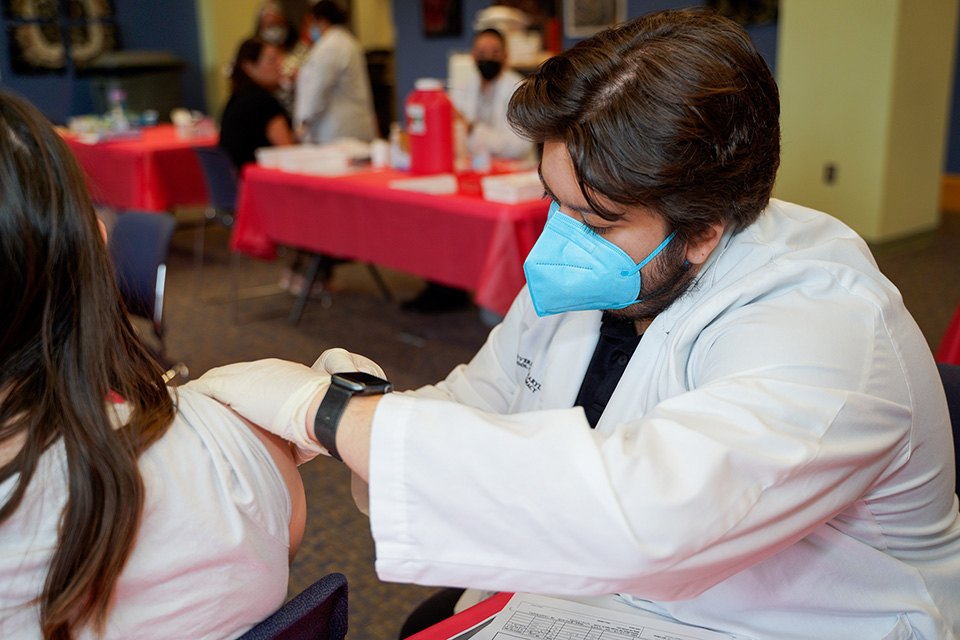 A student pharmacist provides a vaccination at the annual vaccination clinic.