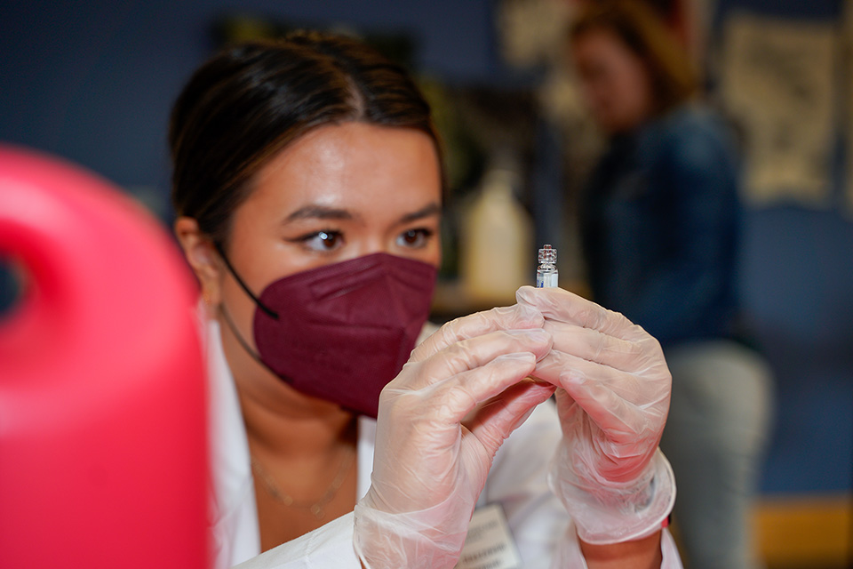 A student pharmacist prepares a vaccine at the annual vaccination clinic.
