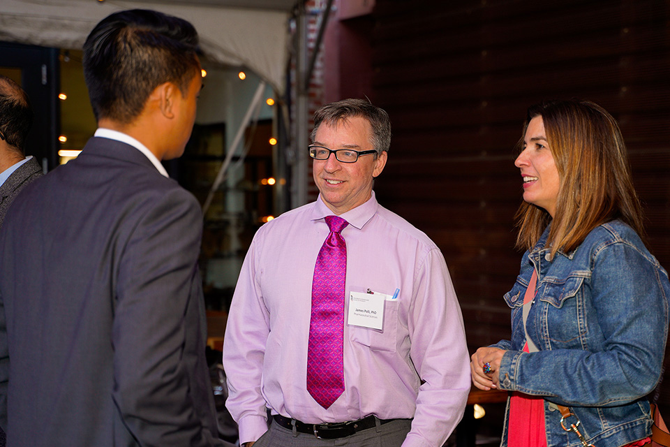 Jim Polli and Ester Villalonga Olives speak to Andrew Do at the Grad Gathering happy hour.