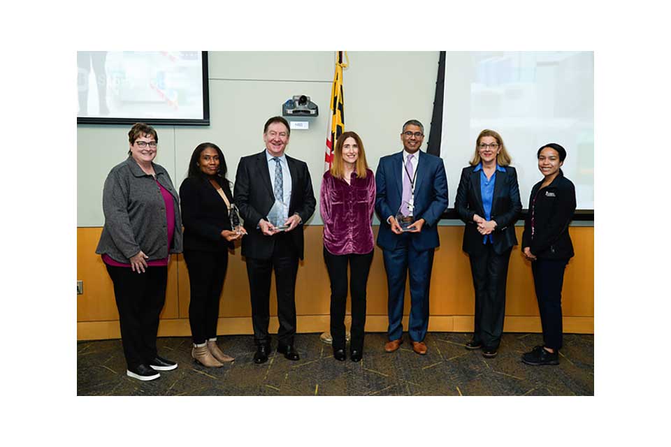 Dean Sarah Michel with faculty and panelists standing at the front of a lecture hall