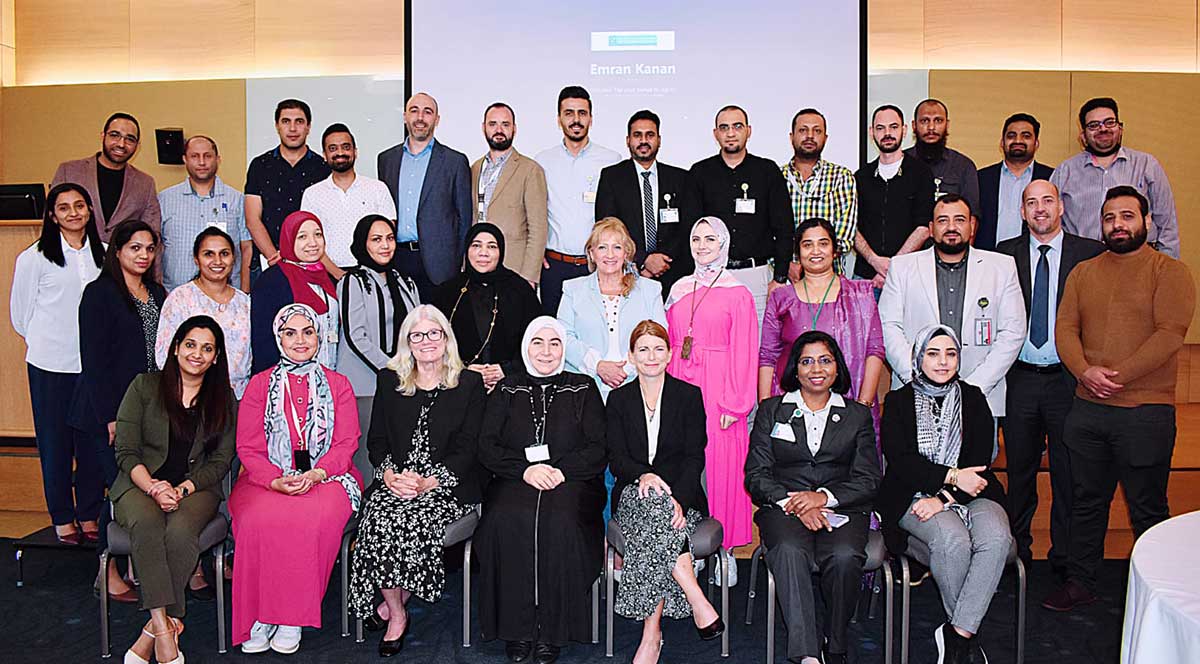 Lamy Center large group in Qatar standing and sitting in front of a presentation screen