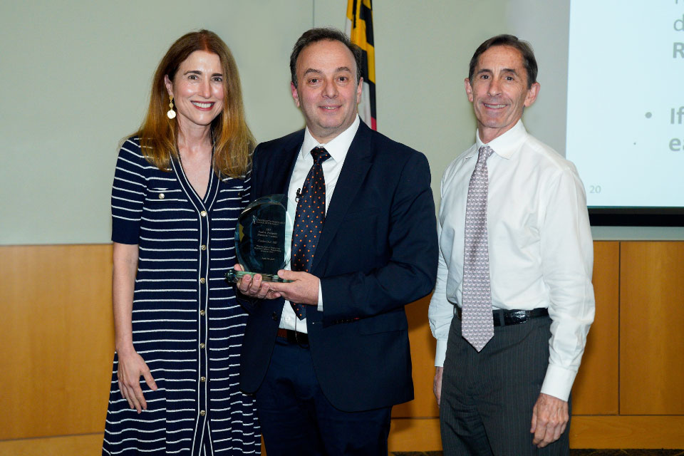 Dean Sarah L.J. Michel, PhD; Carlos Doti, MD; and C. Daniel Mullins, PhD, standing in Pharmacy Hall, facing the camera and smiling