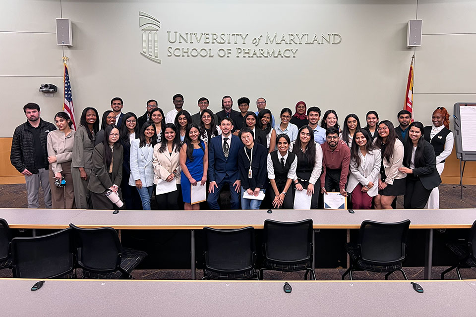Group of MS in Pharmaceutical Sciences students and faculty posing together at a capstone poster presentation event.