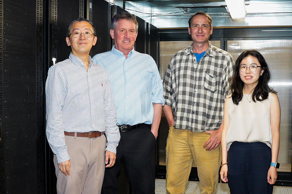 From left to right, Wenbo Yu, Alexander MacKerell, Jr., Ronald Kasl, and Yiling Nan stand in front of server racks in the CADD Center.