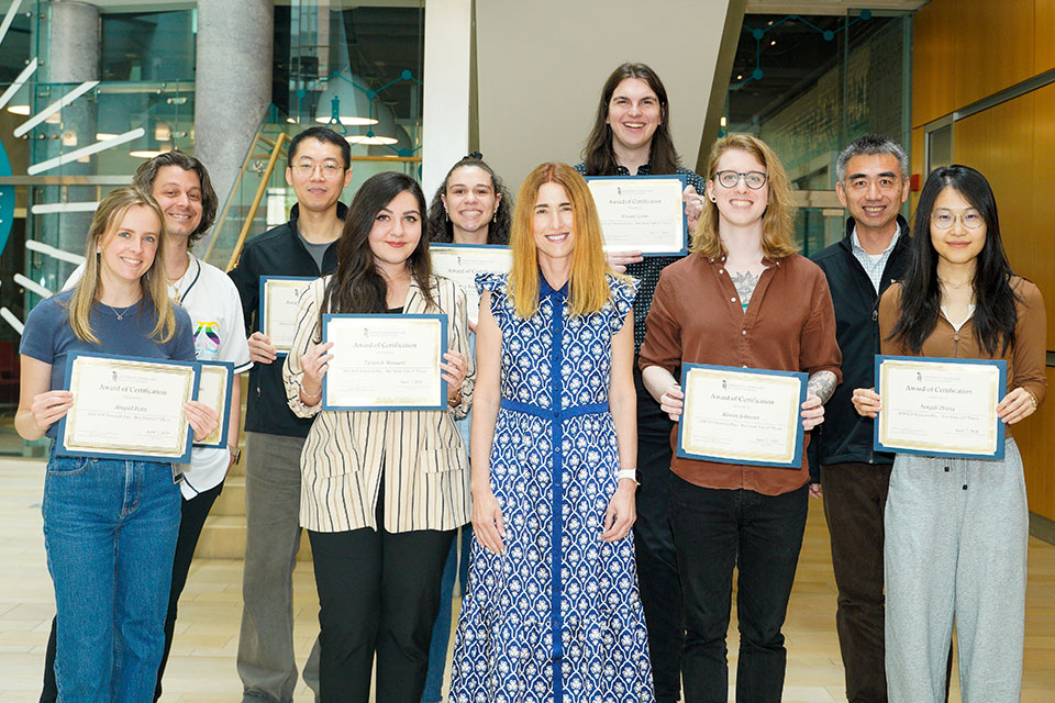 Research Day award winners holding certificates, posing with Dean Sarah L.J. Michel and Fengtian Xue in Pharmacy Hall.