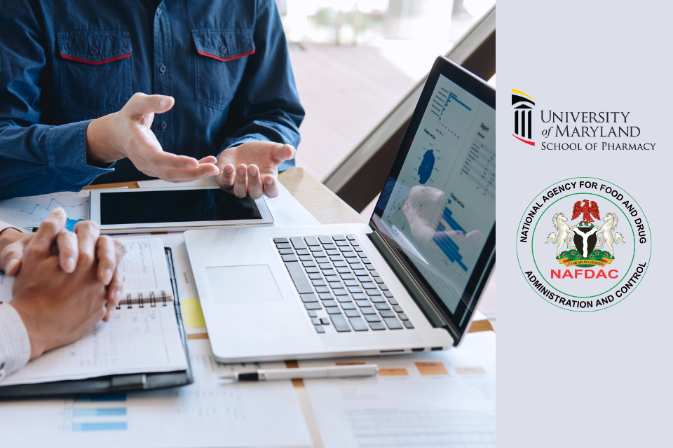 Two people review data on a laptop during a meeting, with charts and documents spread across a table. University of Maryland School of Pharmacy logo and NAFDAC logo displayed on the right.